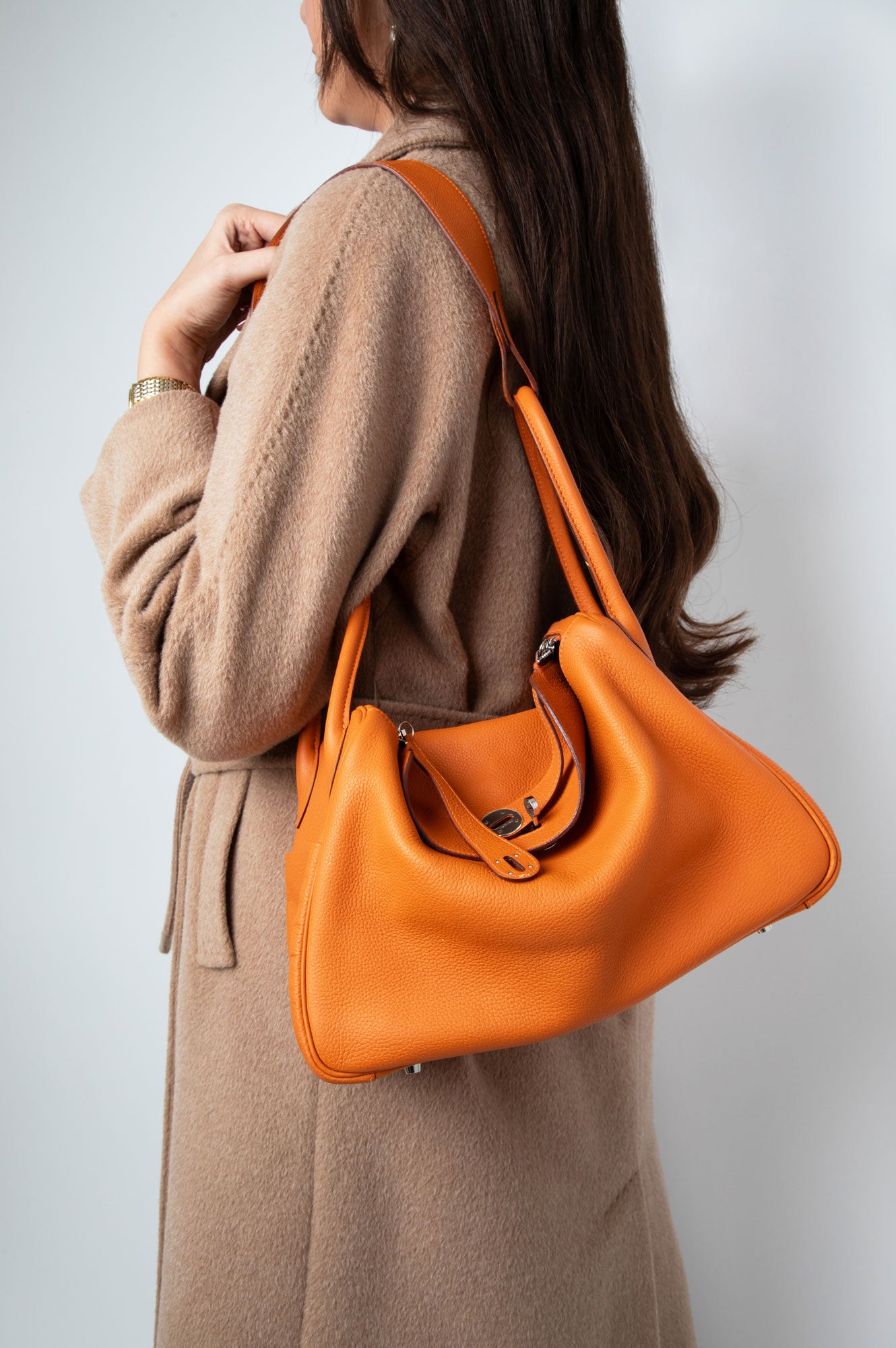 A Women wearing Hermes Orange Lindy 34